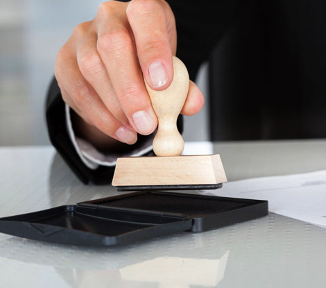 A person is using a rubber stamp on a table.